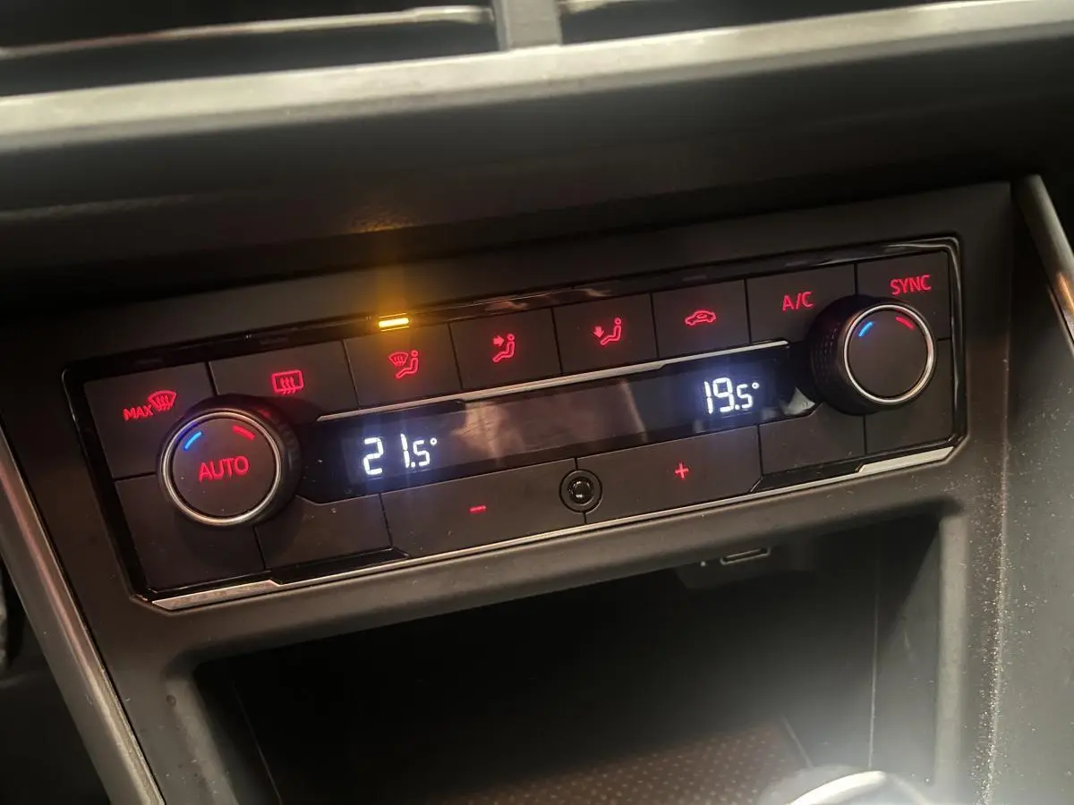 Panneau de climatisation automatique bi-zone avec réglages numériques dans une Volkswagen Polo orange 2019.