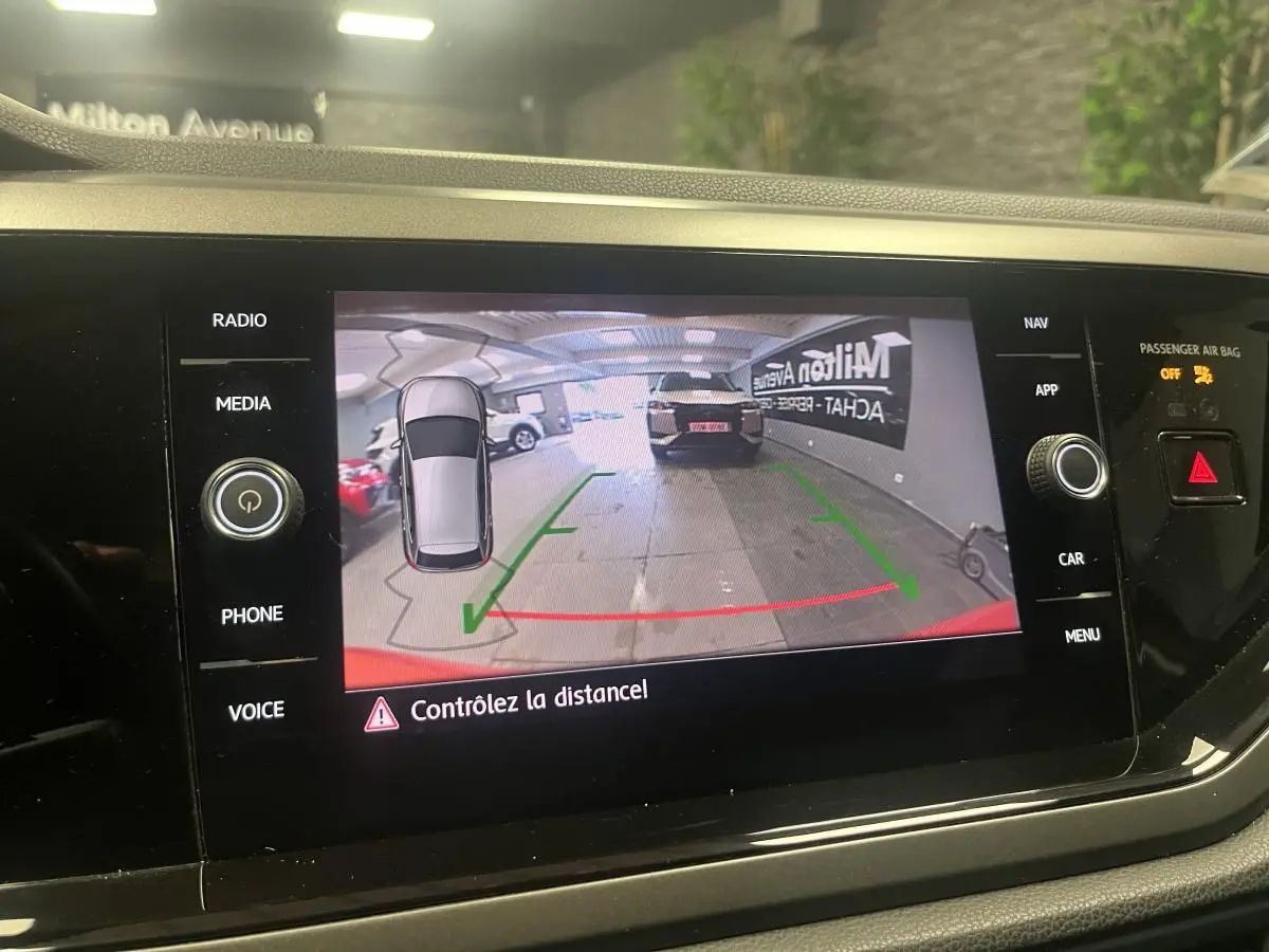 Affichage de la caméra de recul dans une Volkswagen Polo orange, vue arrière avec guidage de trajectoire.