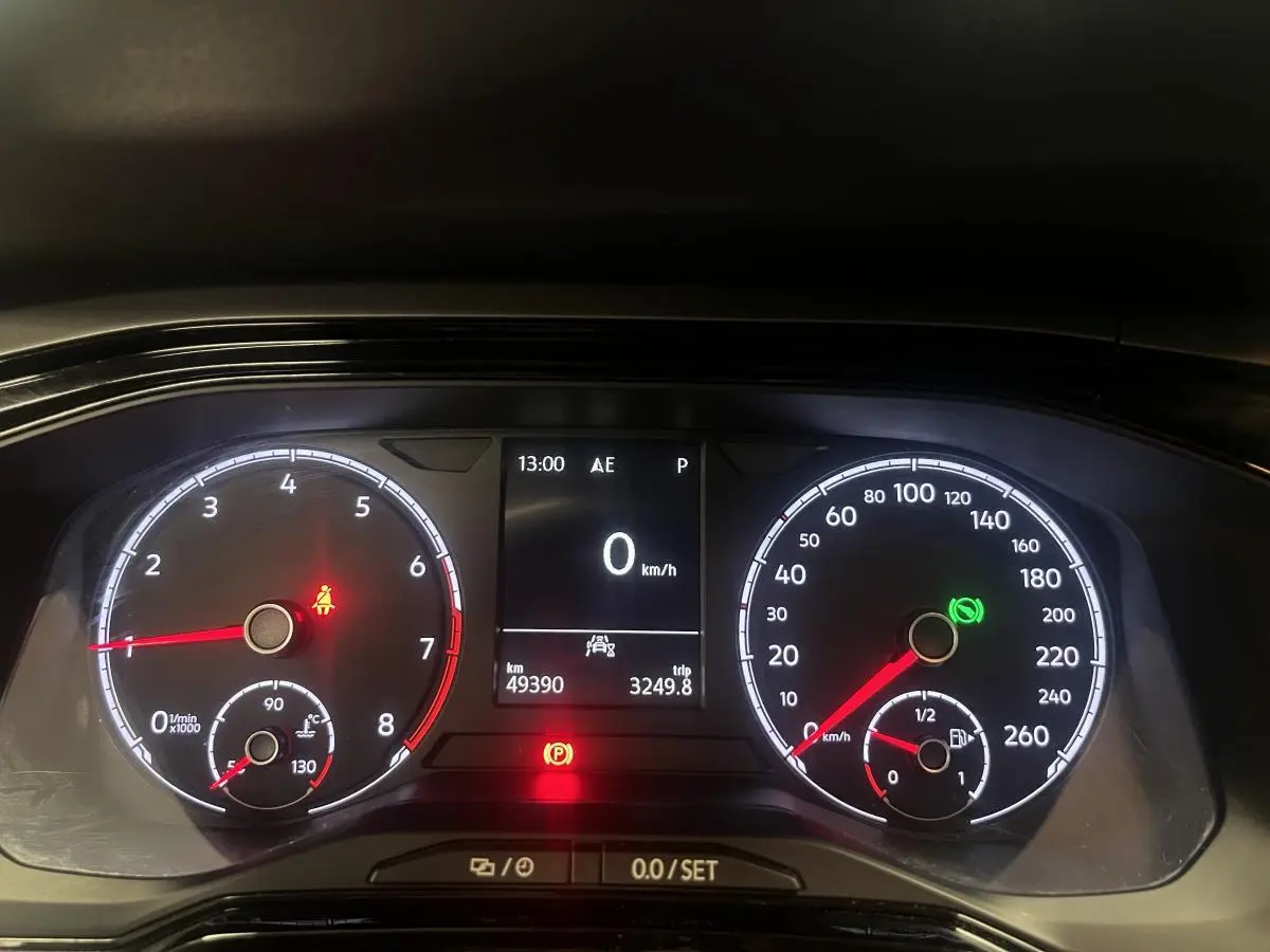 Tableau de bord numérique de Volkswagen Polo orange 2019, affichage vitesse à 0 km/h et témoins allumés.
