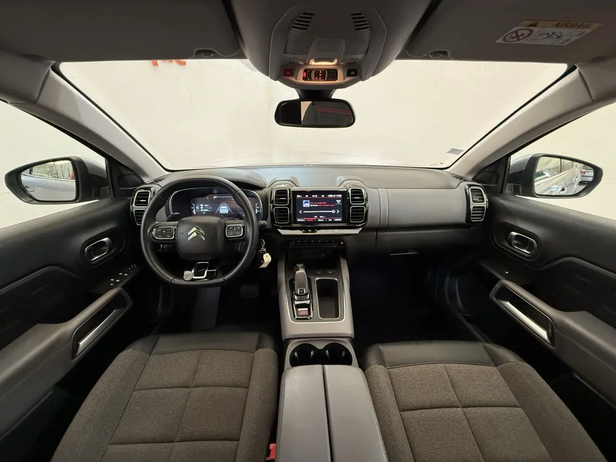 Vue intérieure avant du Citroën C5 Aircross 2020, tableau de bord moderne avec écran tactile et volant cuir multifonctions.