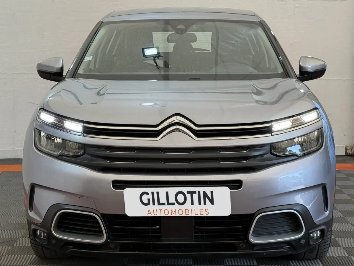 Vue frontale d'un Citroën C5 Aircross gris clair 2020 avec feux LED allumés et calandre distinctive noire.