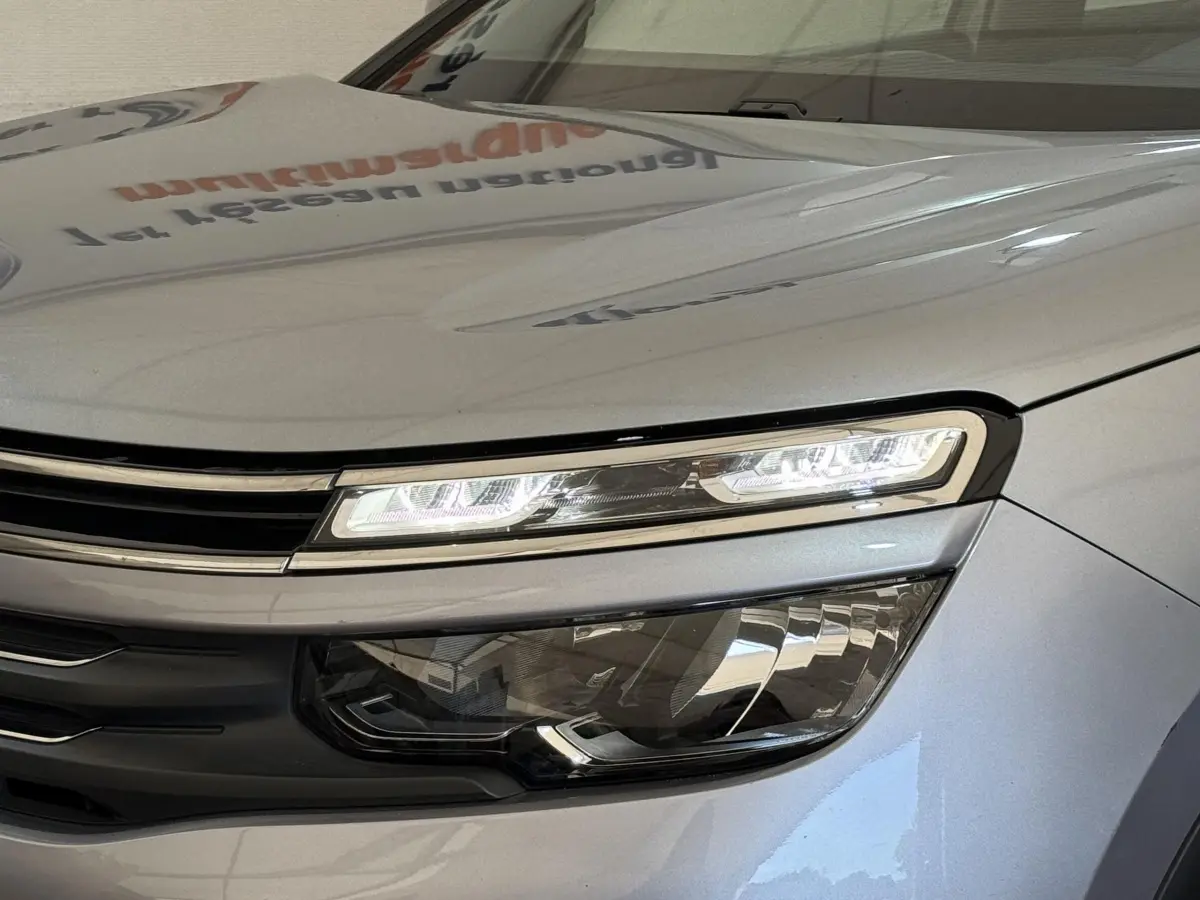 Gros plan sur le phare avant droit LED du Citroën C5 Aircross gris clair, soulignant ses lignes modernes et élégantes.