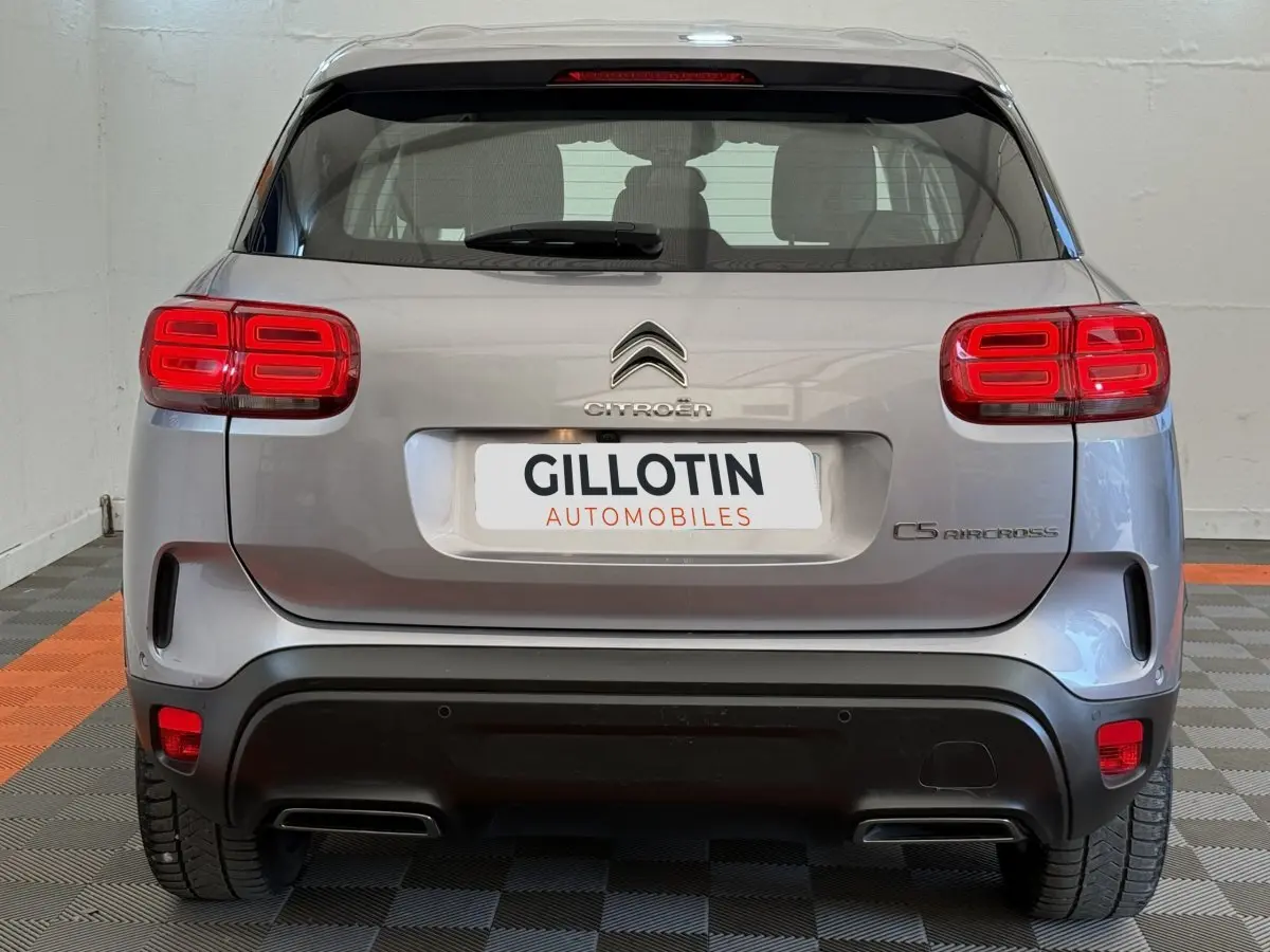 Vue arrière d'un Citroën C5 Aircross gris clair avec feux arrière LED et double sortie d'échappement intégrée.