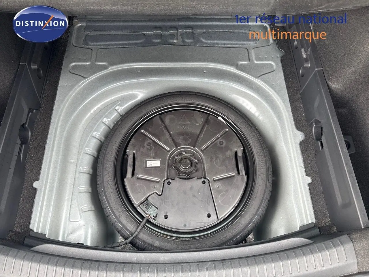 Vue plongeante sur la roue de secours dans le coffre d'une CUPRA LEON ST gris magnetic metal 2024.