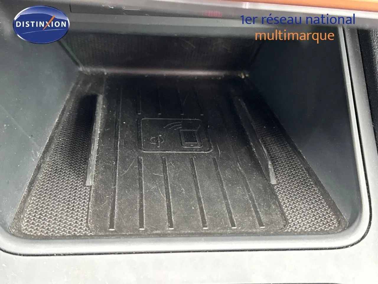 Gros plan sur le chargeur sans fil noir intégré dans la console centrale d'une CUPRA LEON ST gris Magnetic Metal.