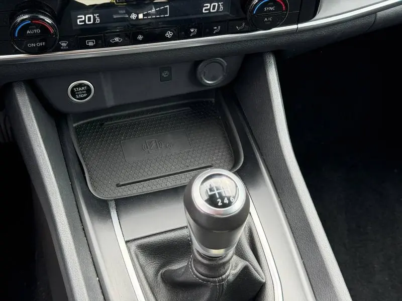 Vue rapprochée de la console centrale du Nissan Qashqai 2025, avec levier de vitesse manuel et commandes climatisation.