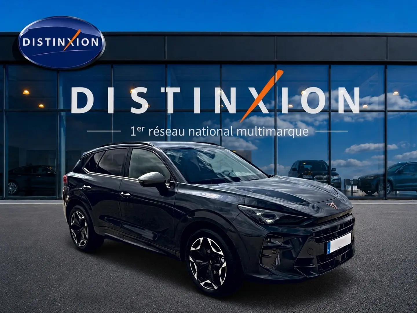 Vue 3/4 avant droit du CUPRA TERRAMAR gris timanfaya avec jantes alu noires et vitres surteintées, devant un showroom Distinxion.