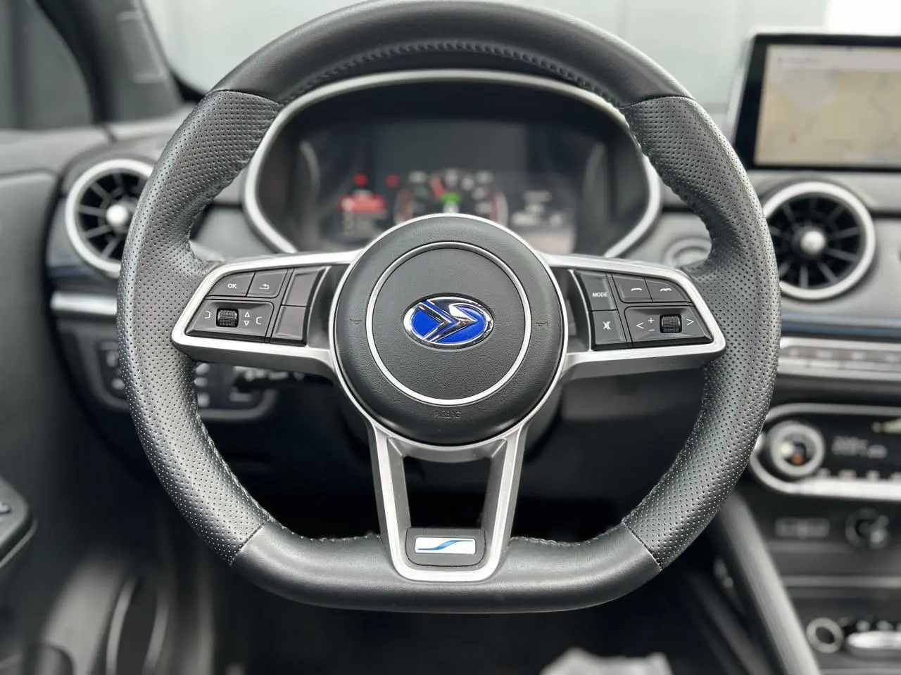 Volant cuir perforé du SERES 3 163 Luxury 2022 avec commandes multifonctions et logo bleu au centre.