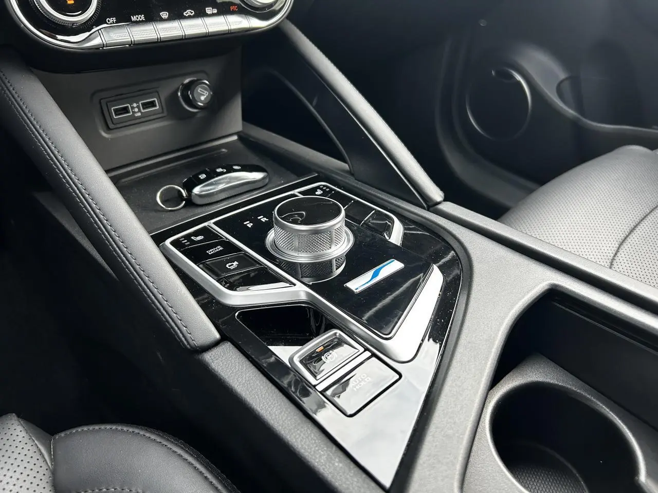 Vue rapprochée de la console centrale noire du SERES 3 163 Luxury 2022 avec molette de commande et bouton Auto-Hold.