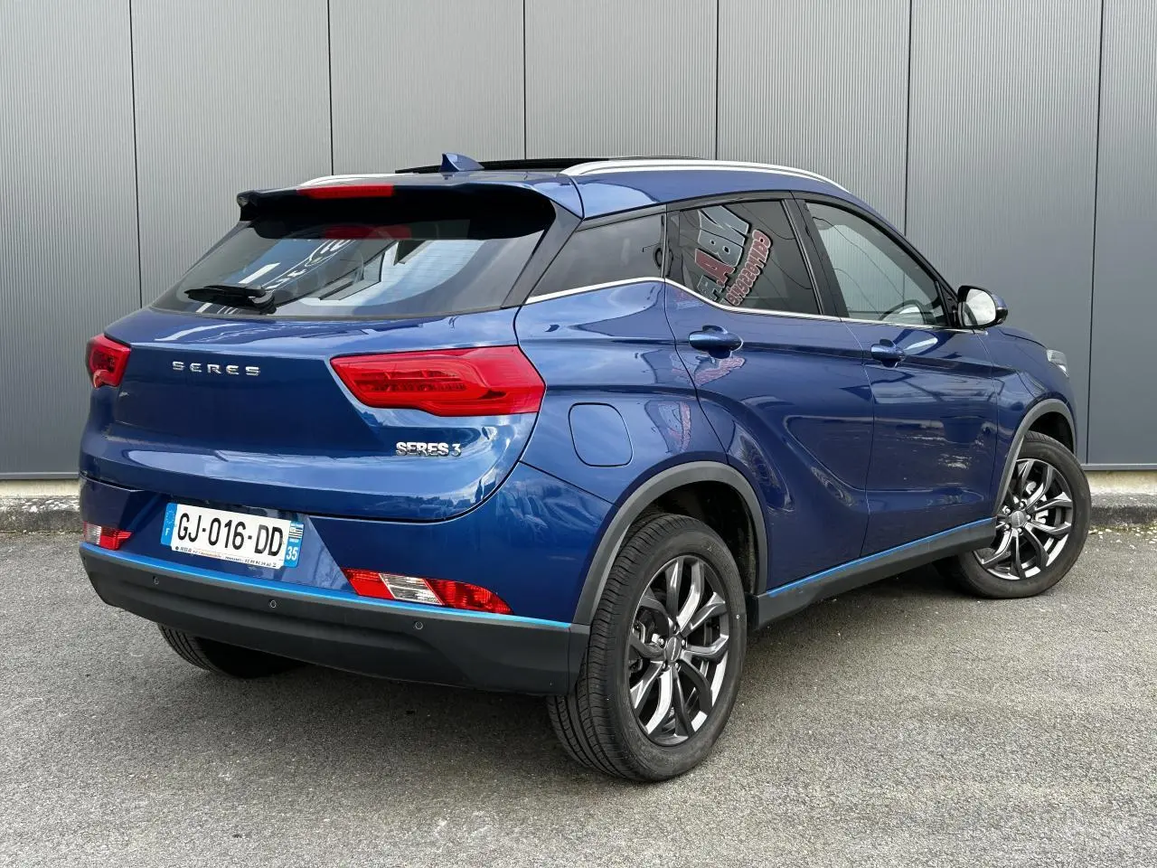Vue 3/4 arrière droite du SUV électrique SERES 3 163 Luxury bleu avec toit panoramique et jantes aluminium.