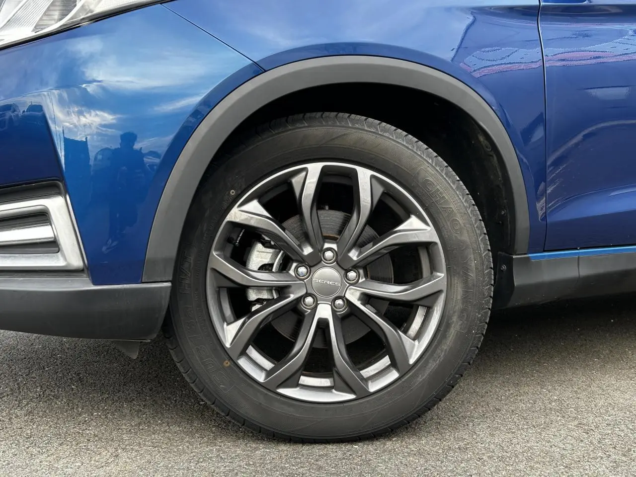 Gros plan sur la roue avant gauche en alliage du SUV électrique SERES 3 bleu, soulignant sa finition élégante.