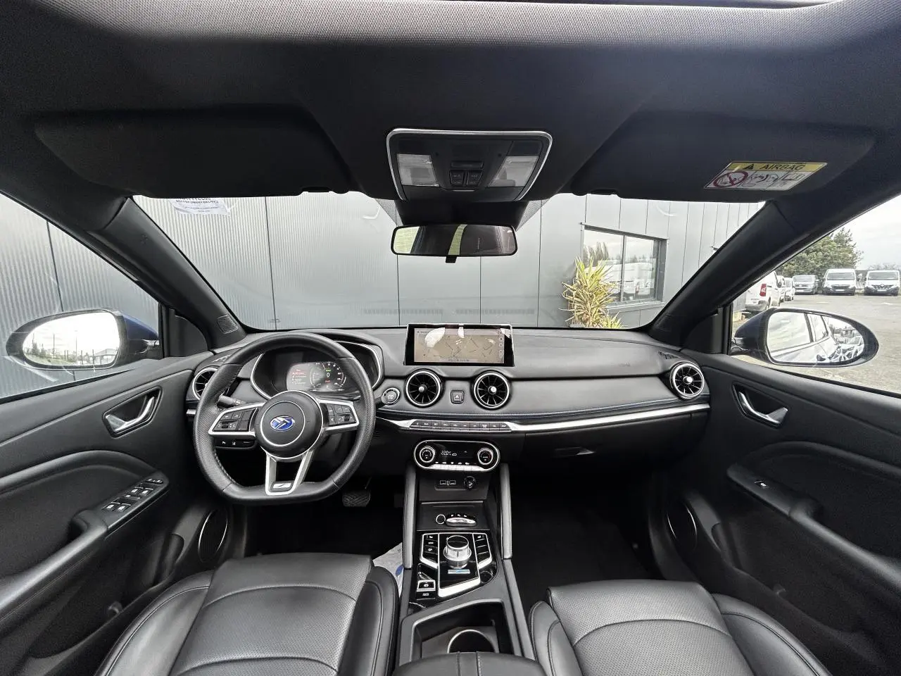 Vue intérieure avant du SERES 3 163 Luxury 2022 avec tableau de bord noir et volant multifonction.