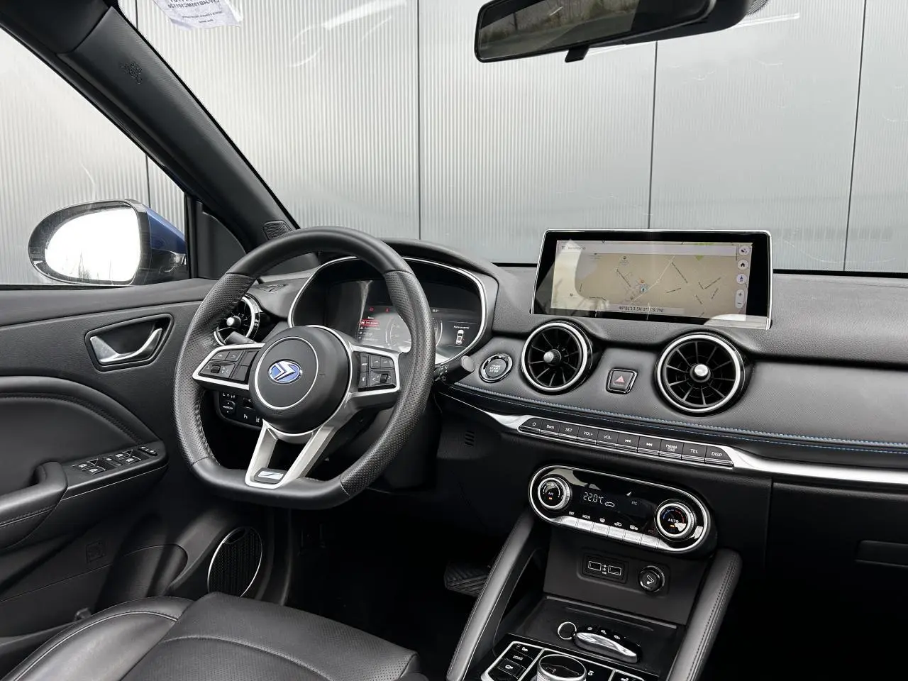 Vue intérieure côté conducteur du tableau de bord du SERES 3 bleu avec écran tactile et volant multifonction.