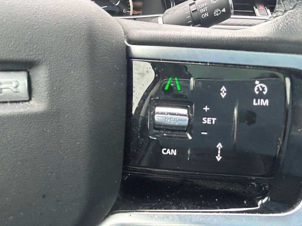 Gros plan sur les commandes de régulateur de vitesse au volant d'un Range Rover Evoque gris foncé 2022.