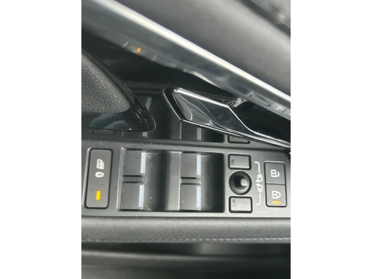 Gros plan sur les commandes des vitres et des rétroviseurs du Range Rover Evoque gris foncé intérieur cuir Ebony.