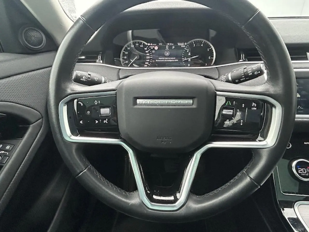 Volant en cuir noir du Range Rover Evoque 2022 avec commandes intégrées et tableau de bord numérique visible en arrière-plan