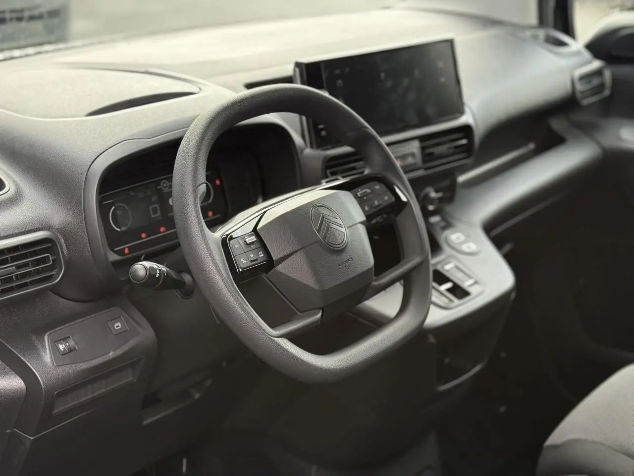 Intérieur du Citroën Berlingo 2025 noir Perla, vue côté conducteur sur le volant multifonction et l'écran tactile central.