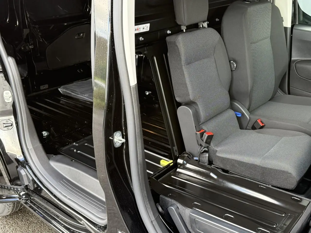Vue intérieure côté droit du Citroën Berlingo Van 2025 noir Perla avec banquette passager rabattue et plancher tôlé.