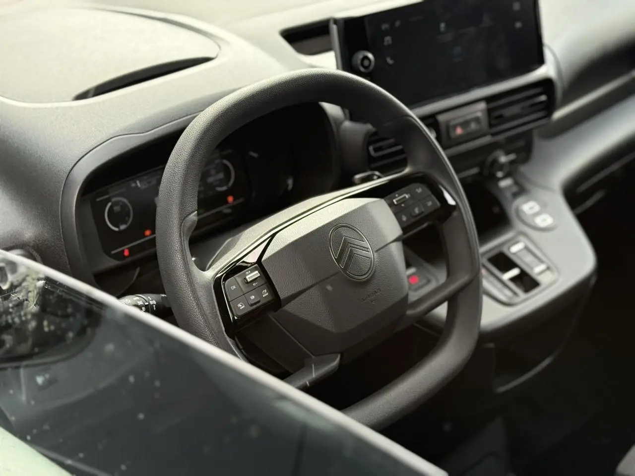 Vue rapprochée du volant multifonctions noir et du tableau de bord digital du Citroën Berlingo Van 2025.