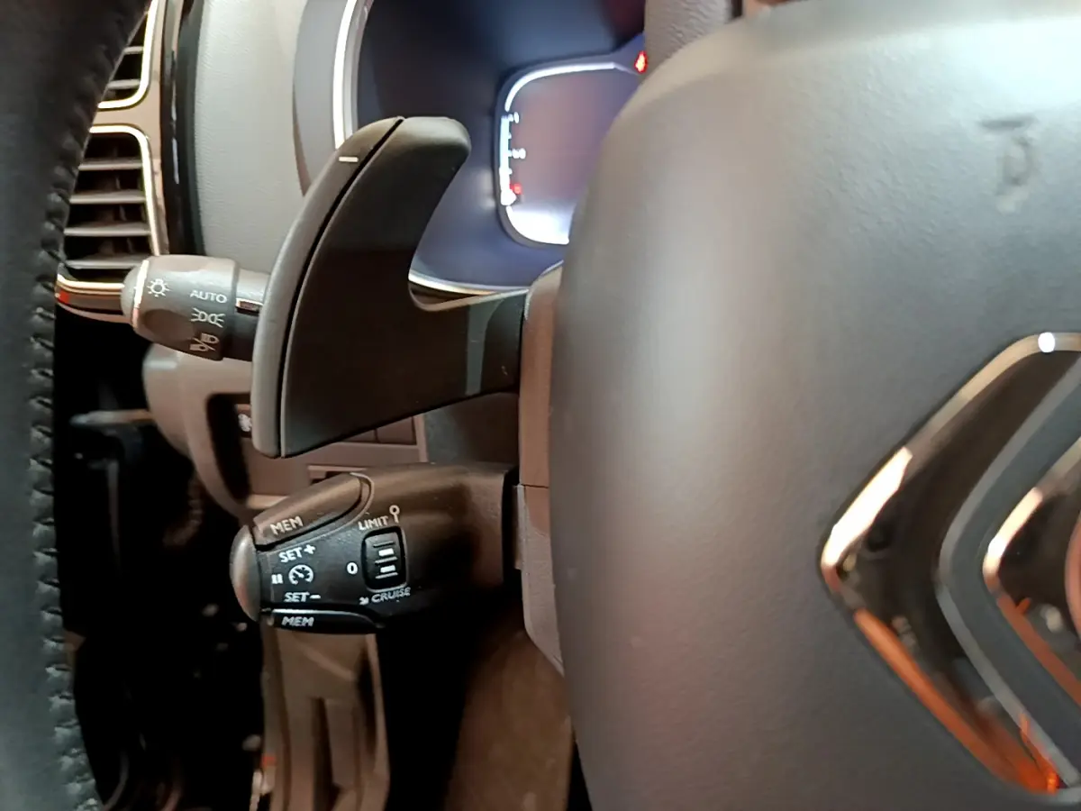 Gros plan sur la commande de régulateur de vitesse à gauche du volant cuir du Citroën C5 Aircross noir 2020.