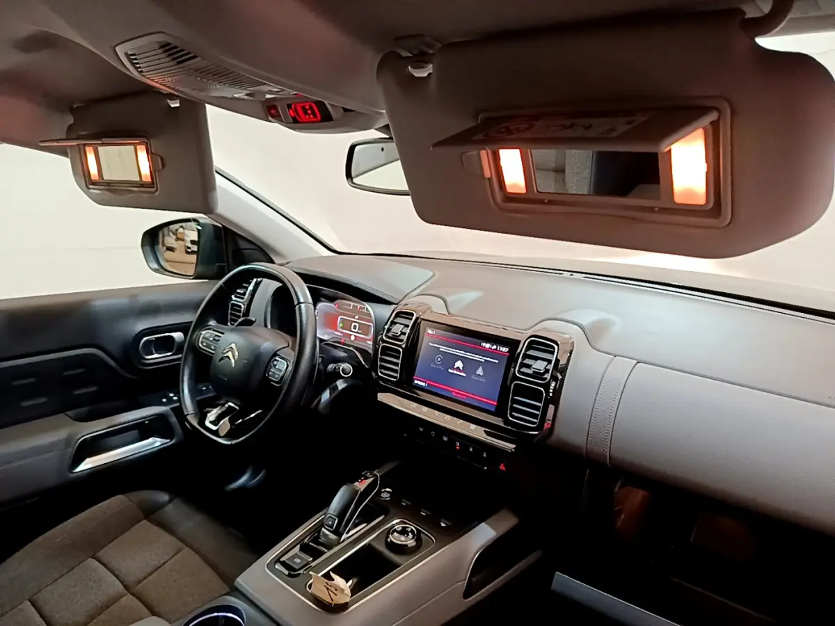 Intérieur du Citroën C5 Aircross noir, vue côté conducteur, tableau de bord avec écran tactile et volant cuir multifonctions.