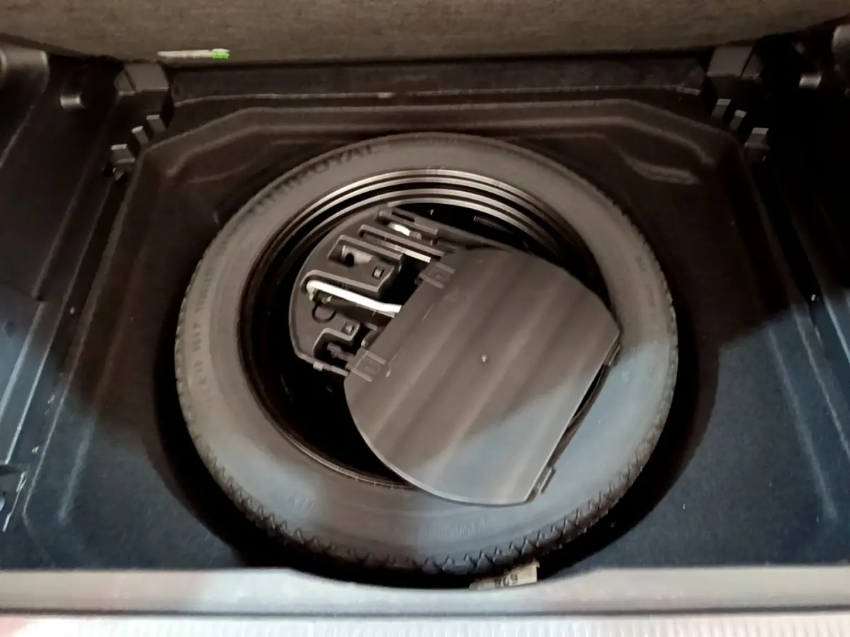 Gros plan sur la roue de secours et son rangement dans le coffre du Citroën C5 Aircross noir de 2020.