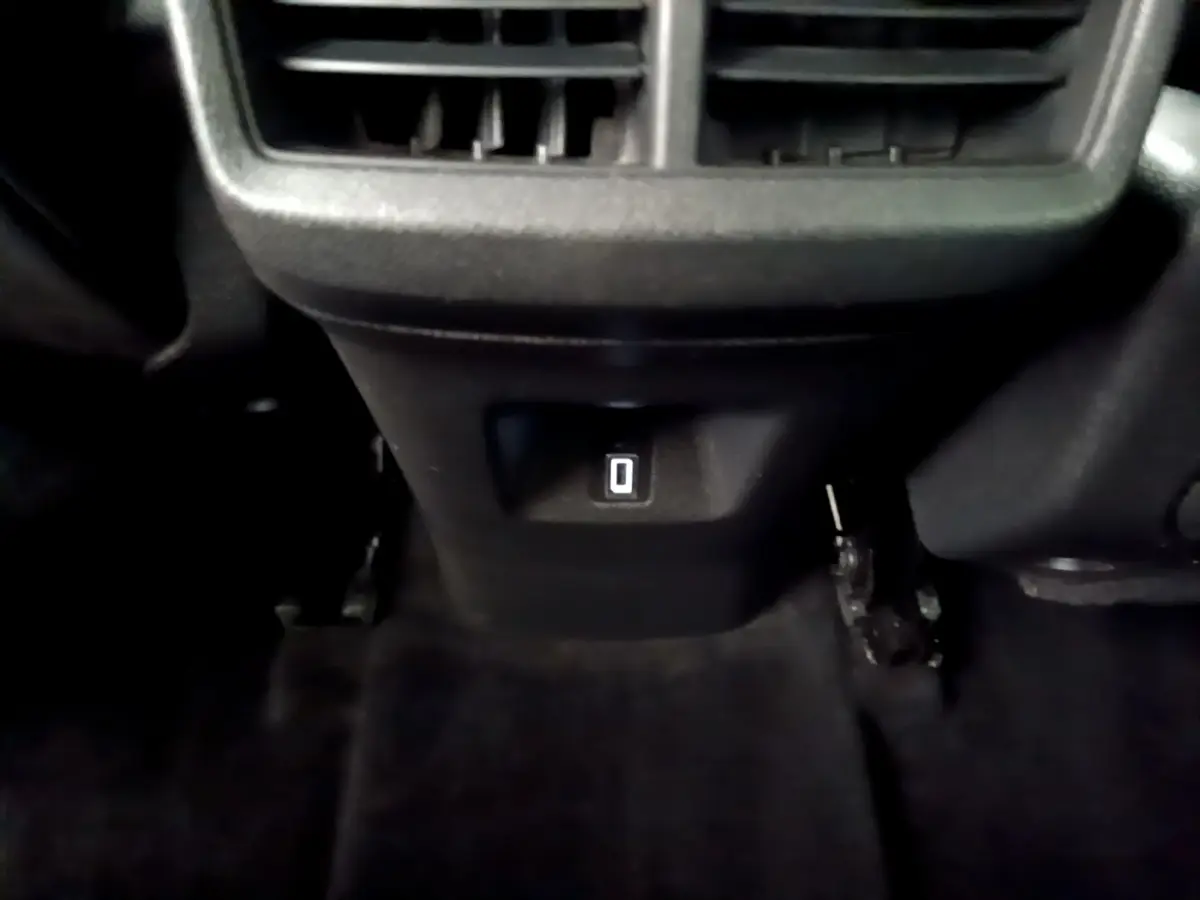 Prise 12V située sous la console centrale arrière du Citroën C5 Aircross noir, avec ventilation au-dessus.