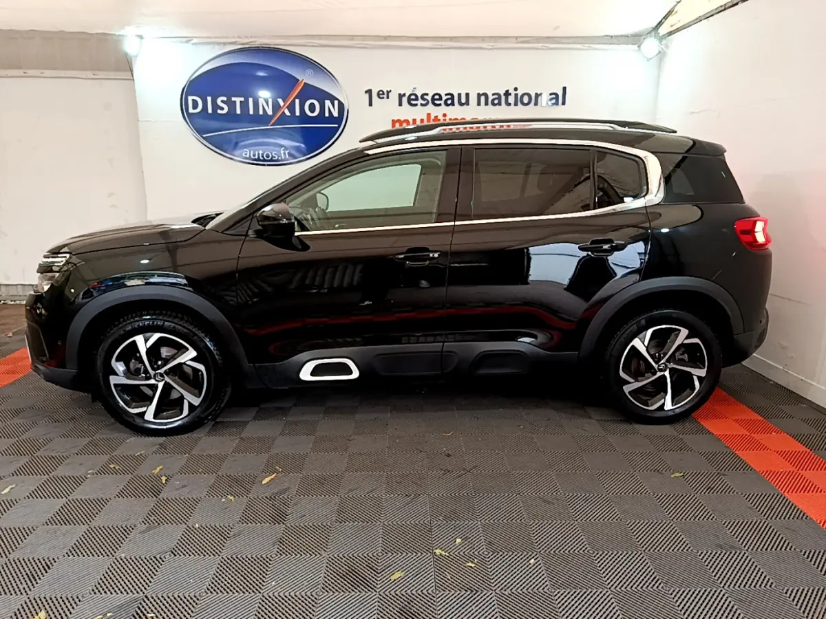Profil droit d'un SUV Citroën C5 Aircross noir avec jantes alliage et détails chromés sous un éclairage intérieur.