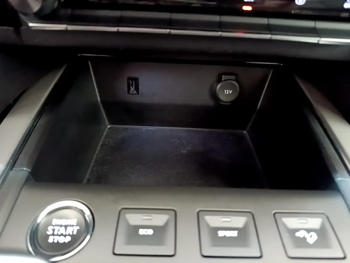 Gros plan sur la console centrale noire du Citroën C5 Aircross avec bouton démarrage et prises 12V visibles
