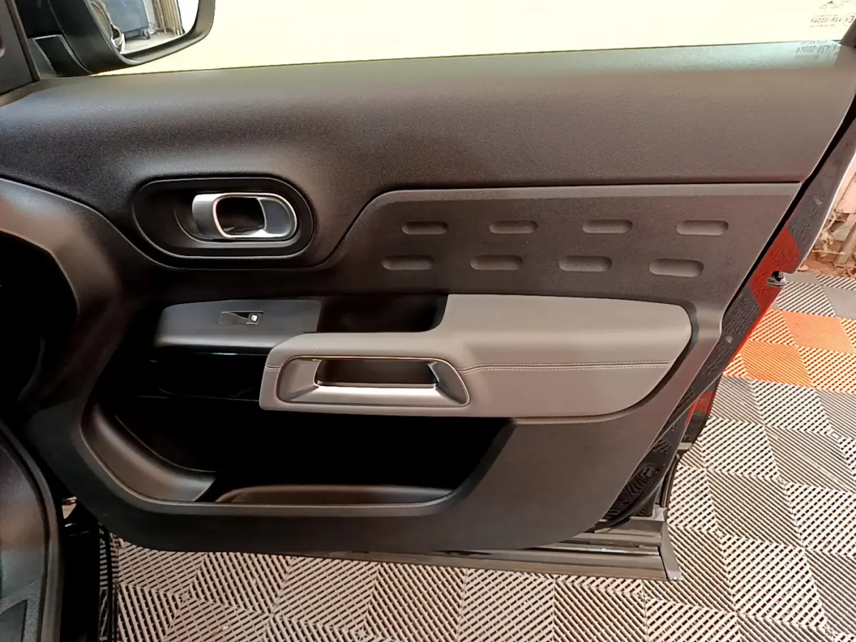 Vue intérieure du panneau de porte côté droit noir et gris du Citroën C5 Aircross 2020 avec poignée argentée.