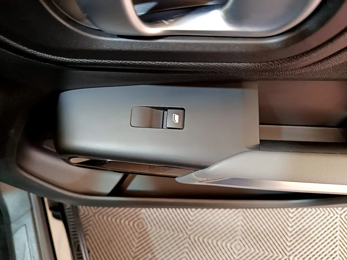 Gros plan sur la commande de lève-vitre côté gauche dans l'habitacle noir du Citroën C5 Aircross 2020.