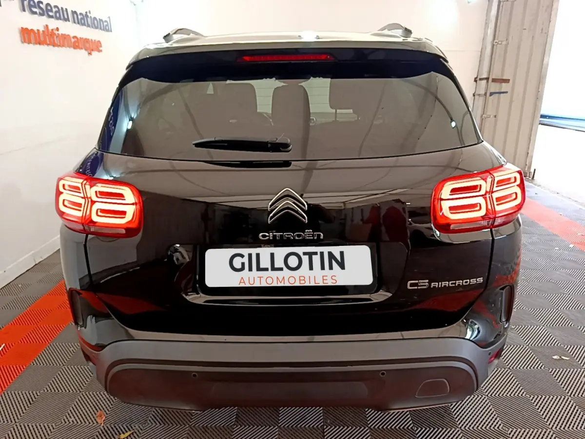 Vue arrière du Citroën C5 Aircross noir avec feux arrière LED allumés dans un garage intérieur.
