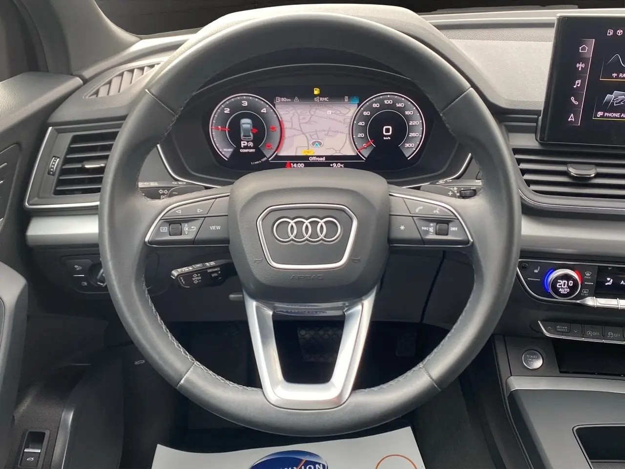 Vue rapprochée du volant cuir noir et du tableau de bord digital d’un Audi Q5 Business Edition S-Line 2022.