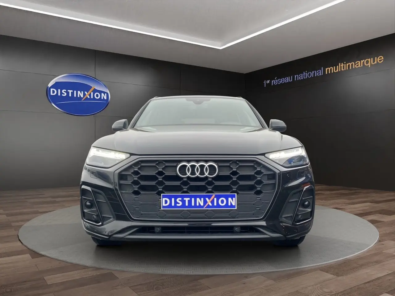 Audi Q5 Business Edition S-Line noir vue de face, avec calandre hexagonale et phares LED allumés.