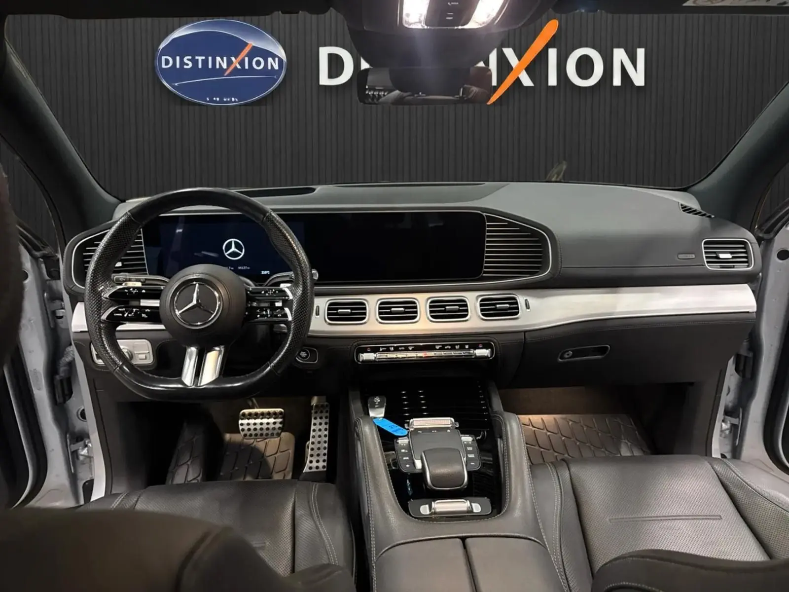 Vue intérieure avant du Mercedes GLE 400 E Hybrid AMG Line 2023, tableau de bord moderne avec cuir noir et écran large.