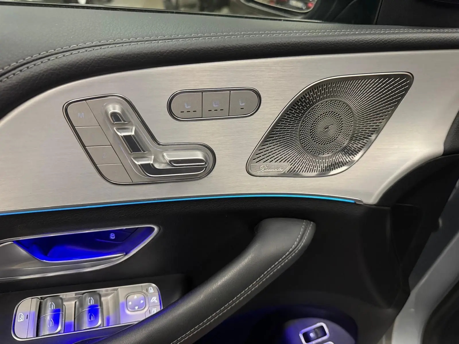 Détail de la porte côté conducteur du Mercedes GLE 400 E Hybrid AMG Line 2023, avec commandes sièges et haut-parleur Burmester.