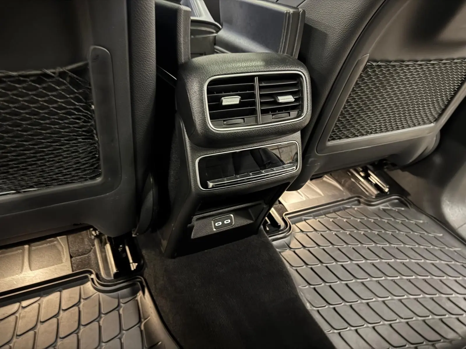 Vue intérieure arrière du Mercedes GLE 400 E Hybrid AMG Line 2023, montrant les aérateurs et ports USB noirs entre les sièges.