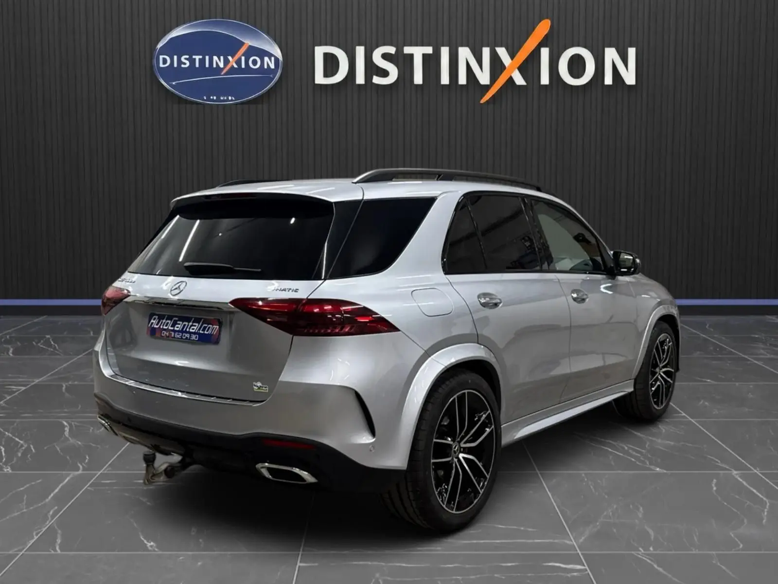 Mercedes GLE 400 e Hybrid AMG Line argent métallisé, vue 3/4 arrière droit, jantes noires et vitres teintées.