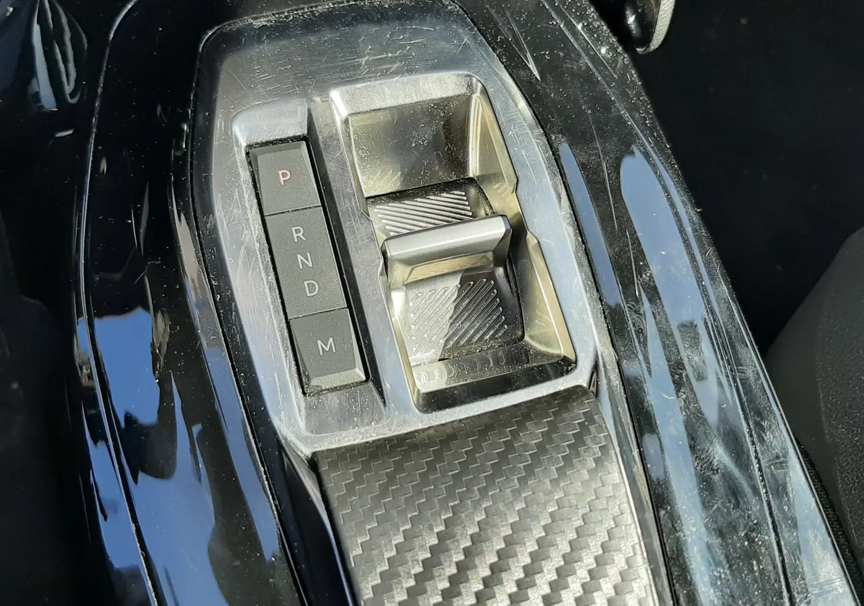 Gros plan sur la commande de boîte automatique noire avec finition carbone du Peugeot 2008 gris platinium 2023.