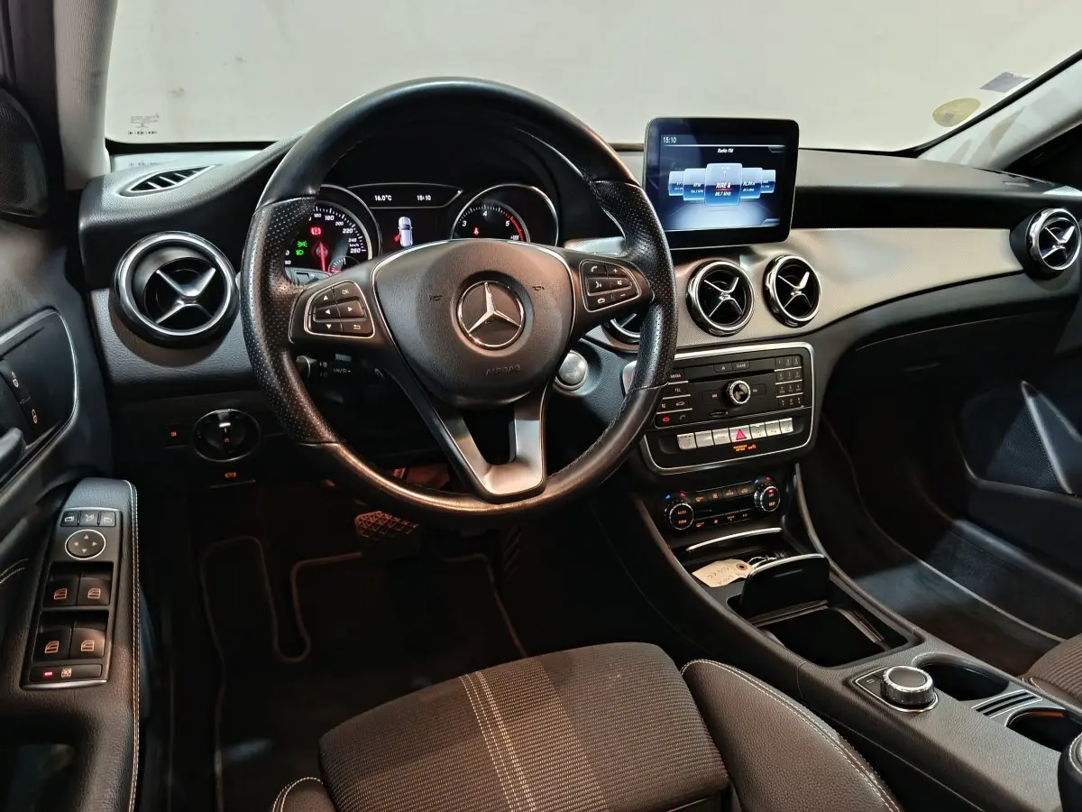 Intérieur noir de la Mercedes GLA 200 d 2018, vue de face sur le volant cuir et le tableau de bord avec écran central.