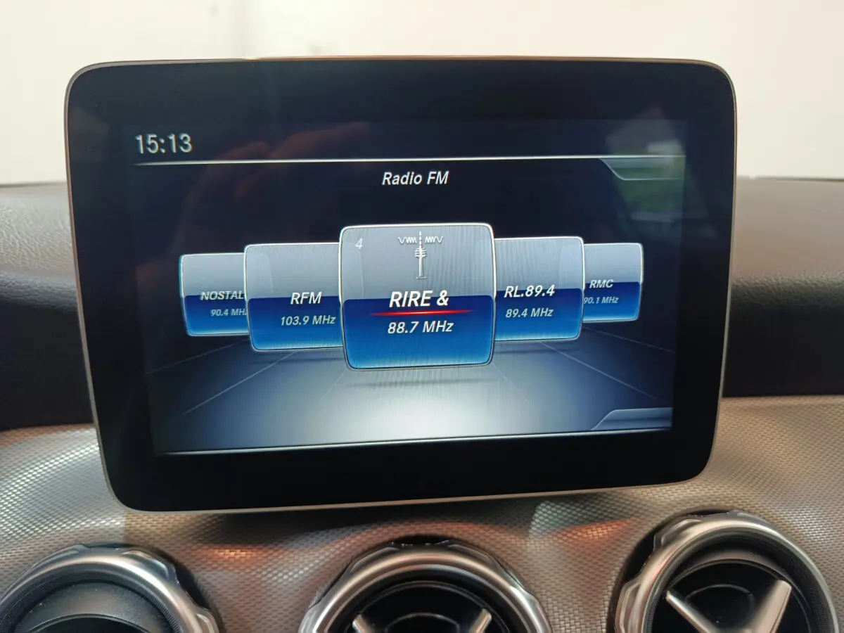 Écran central tactile affichant la radio FM dans l'habitacle du Mercedes GLA 200 d gris clair, vue de face rapprochée.