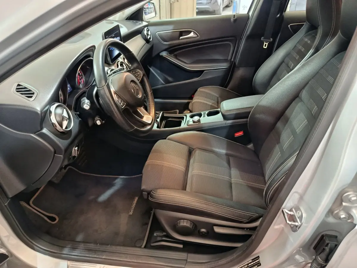Intérieur vue côté conducteur d'une Mercedes GLA 200 d gris clair, volant cuir multifonctions et sièges tissu noir.