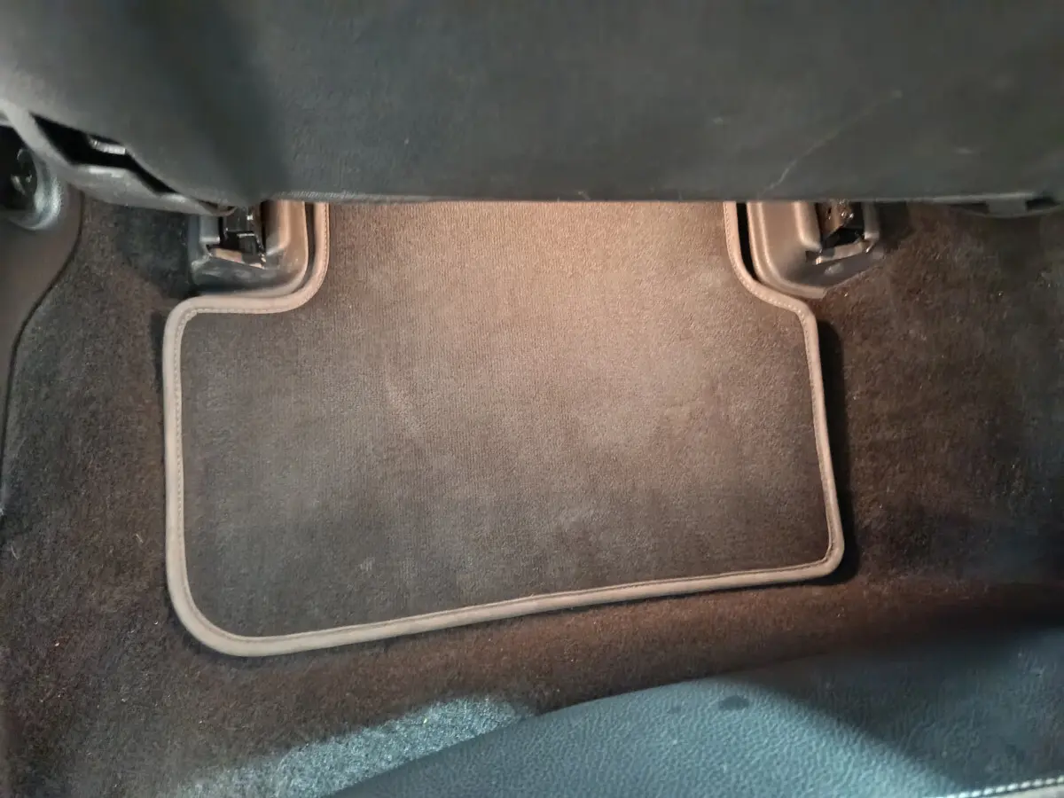 Tapis de sol noir côté passager arrière d'un Mercedes GLA 200 d Business Executive gris clair, vue intérieure basse.