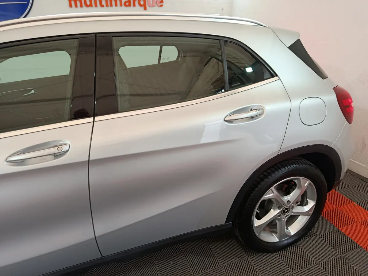 Vue latérale côté droit du Mercedes GLA 200 d gris clair, mettant en valeur les poignées chromées et la jante alliage.