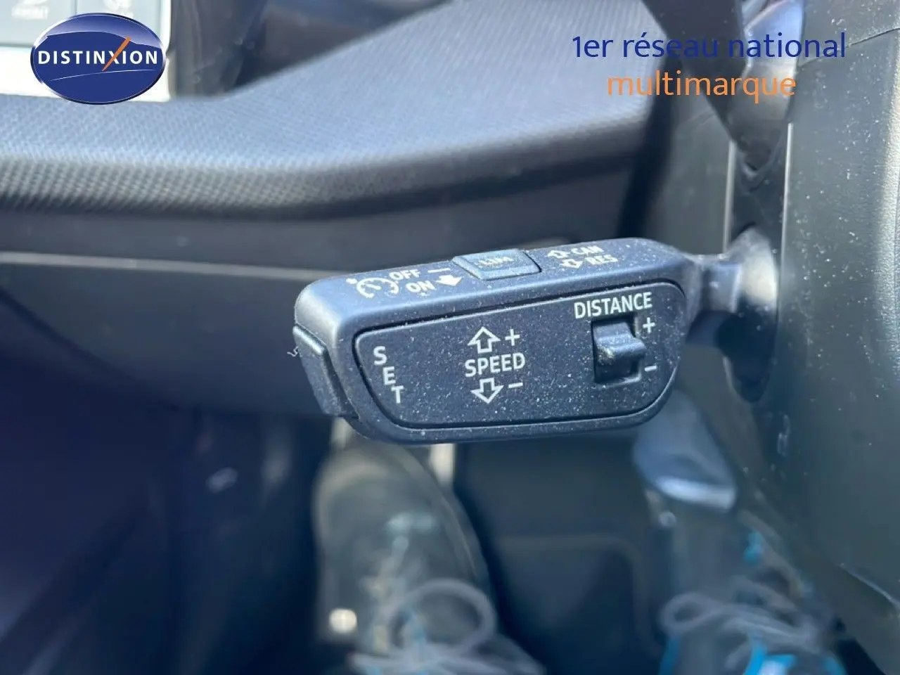 Gros plan sur la commande de régulateur de vitesse adaptatif dans l'habitacle de l'Audi A3 Sportback blanc Ibis 2025.