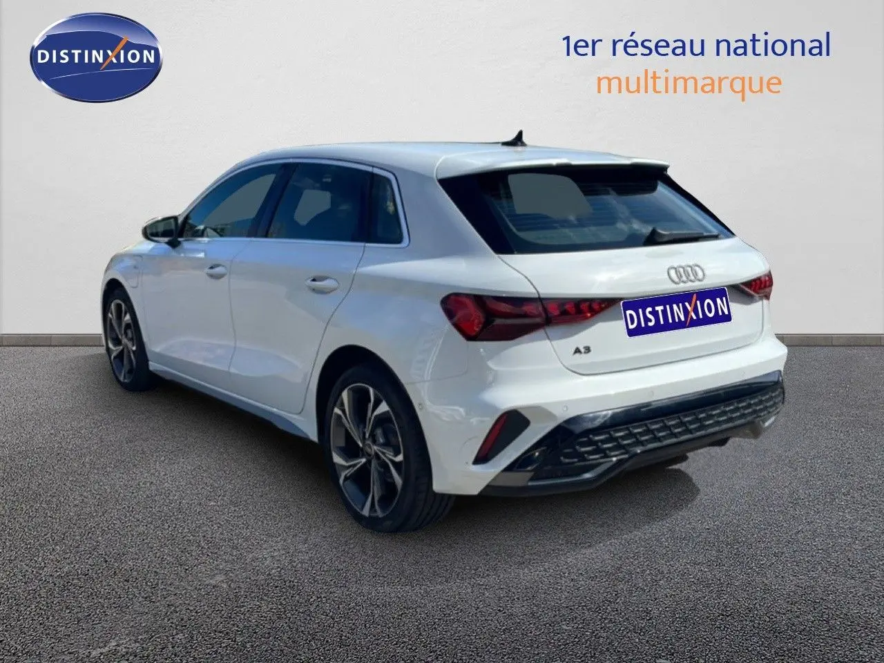 Audi A3 Sportback blanc Ibis vue 3/4 arrière droit, avec jantes alliage et feux arrière LED distinctifs.