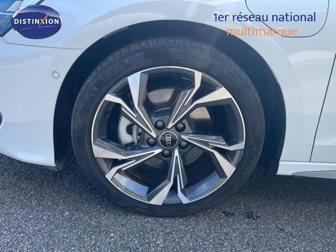 Gros plan sur la roue avant gauche d'une Audi A3 Sportback blanche Ibis avec jante alliage S-Line distinctive.