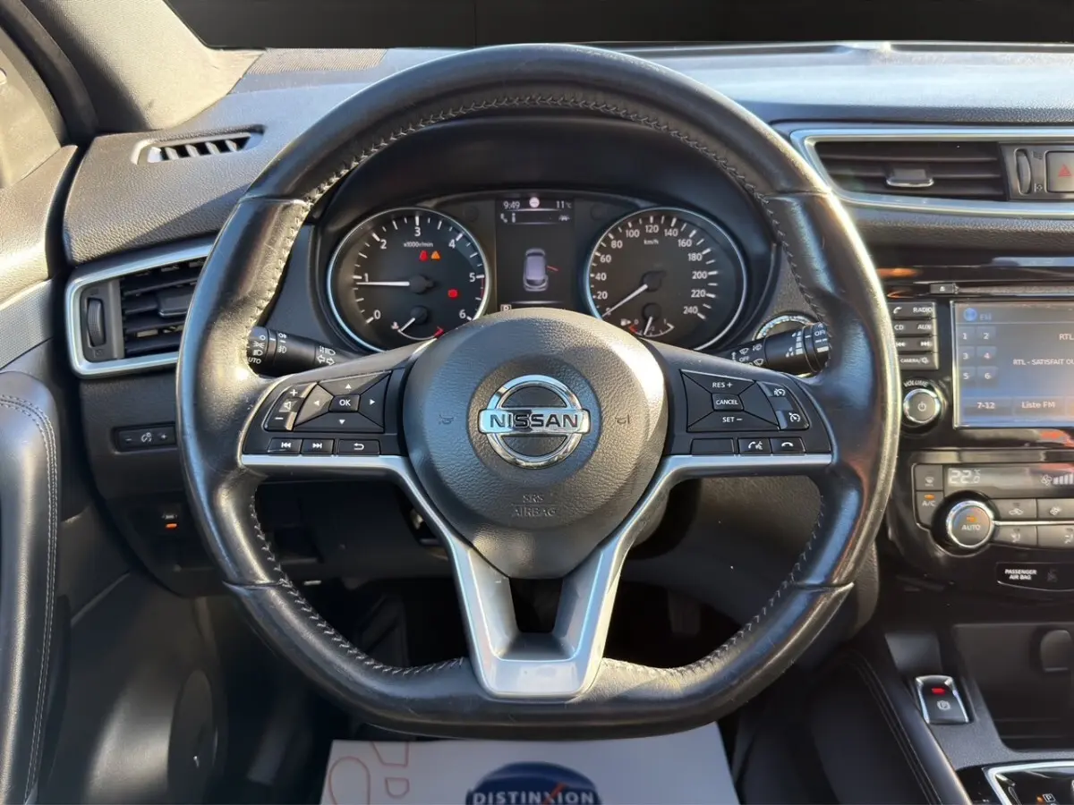 Vue intérieure centrée sur le volant cuir noir du Nissan Qashqai 1.6 DCI 130 Tekna+ avec tableau de bord et écran tactile.