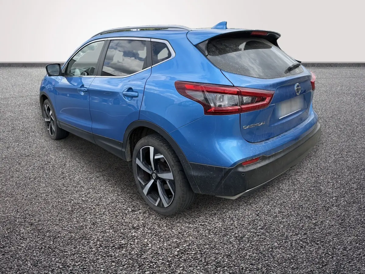 Nissan Qashqai bleu en 3/4 arrière droit, avec jantes alliage noires et toit avec spoiler noir.
