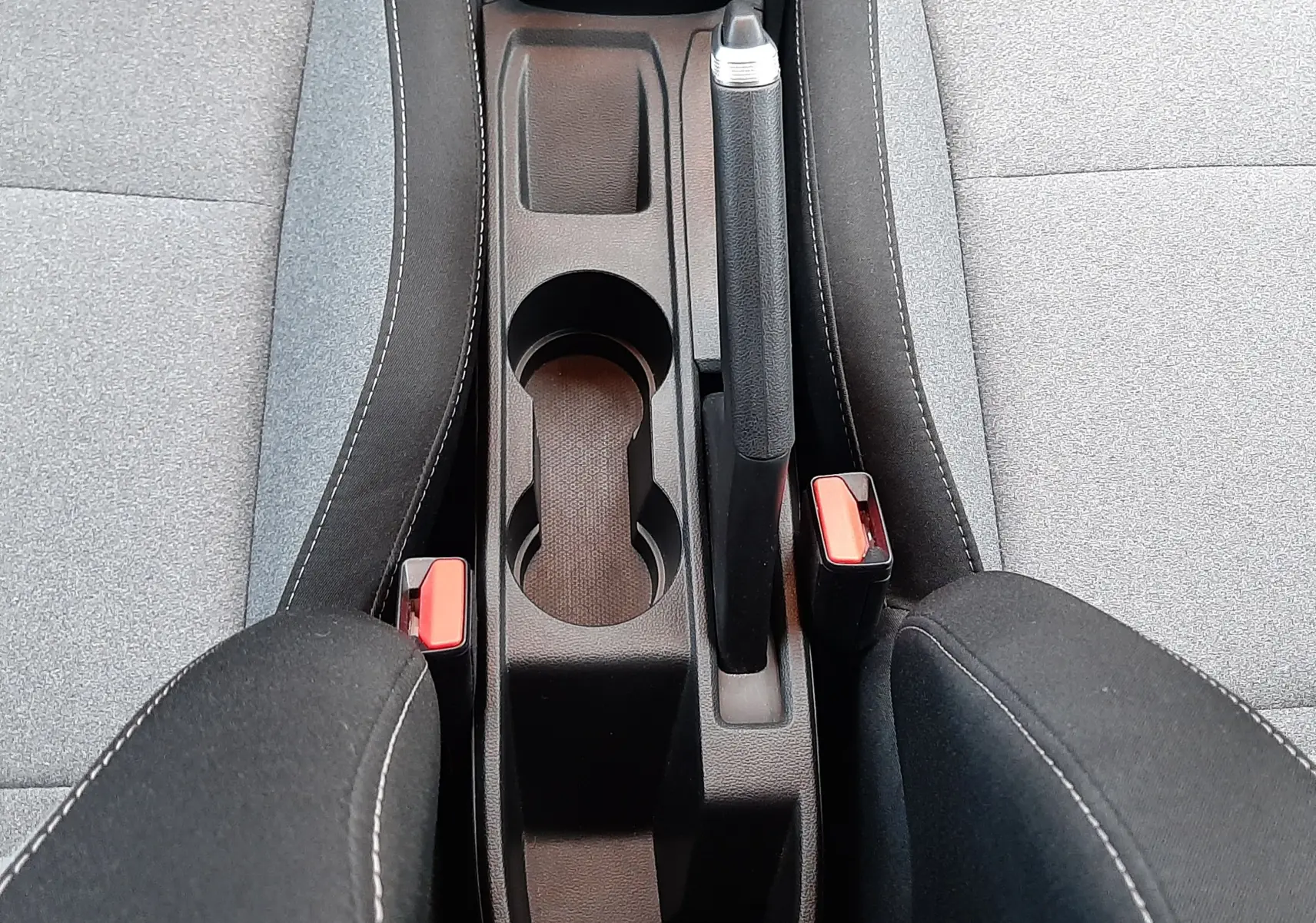 Vue plongeante sur la console centrale et les sièges gris tissu de la Renault Clio V TCE 90CH Evolution 2025.